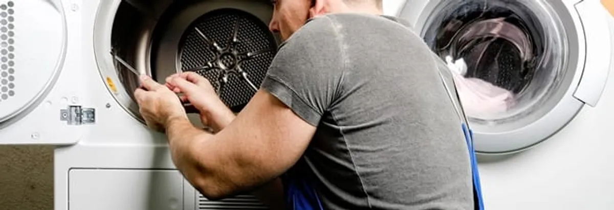 Dryer repair technician fixing a clothes dryer drum in Albany, NY