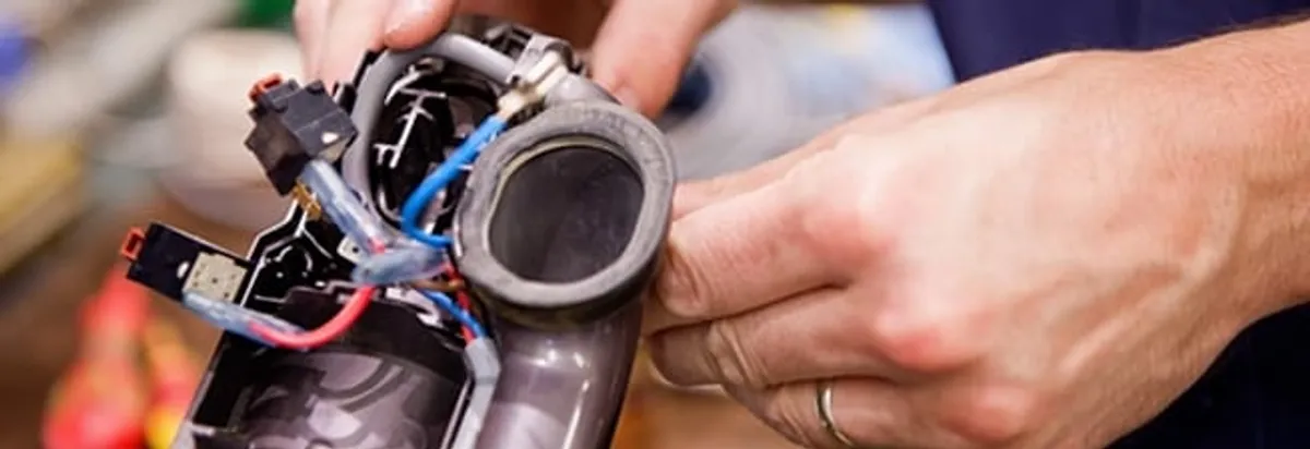 Vacuum repair technician reconnecting wiring and components in Albany, NY