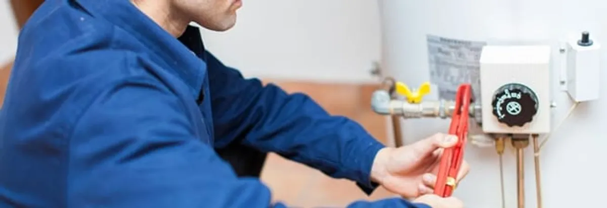 Water heater repair technician adjusting the temperature control and gas valve in Albany, NY
